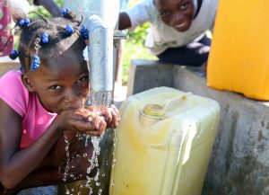 On its 36th anniversary of serving the poor, Food For The Poor thanks its donors for what they have done for the destitute in 17 countries in the Caribbean and Latin America. Food For The Poor has installed a total of 2,064 water wells. This little girl in Haiti is happy to have clean, fresh water from a Food For The Poor water well to drink. (Photo by Food For The Poor)